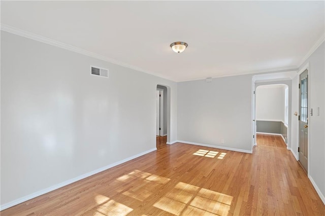7712 Mcgee St, Kansas City, MO 64114 - empty room with arched walkways, ornamental molding, and light wood-style flooring
