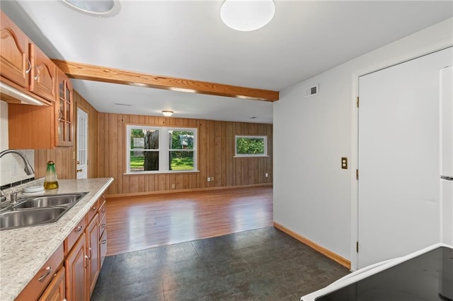 7712 Mcgee St, Kansas City, MO 64114 - kitchen featuring light countertops, brown cabinets, glass insert cabinets, wooden walls, and beamed ceiling