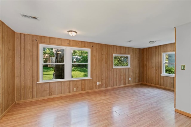 7712 Mcgee St, Kansas City, MO 64114 - unfurnished room featuring wood finished floors, plenty of natural light, and wooden walls