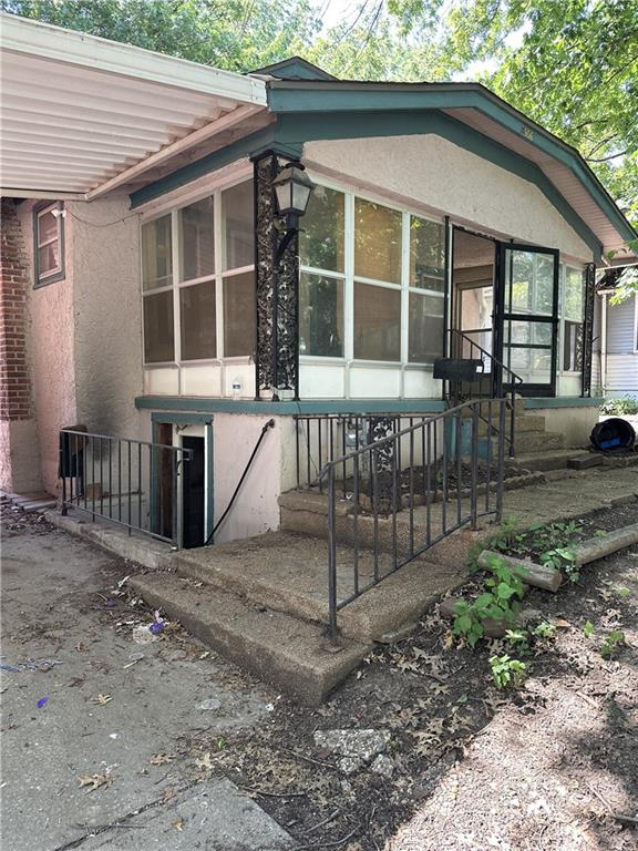 1906 S Willow Ave, Independence, MO 64052 - view of side of home featuring a sunroom and stucco siding