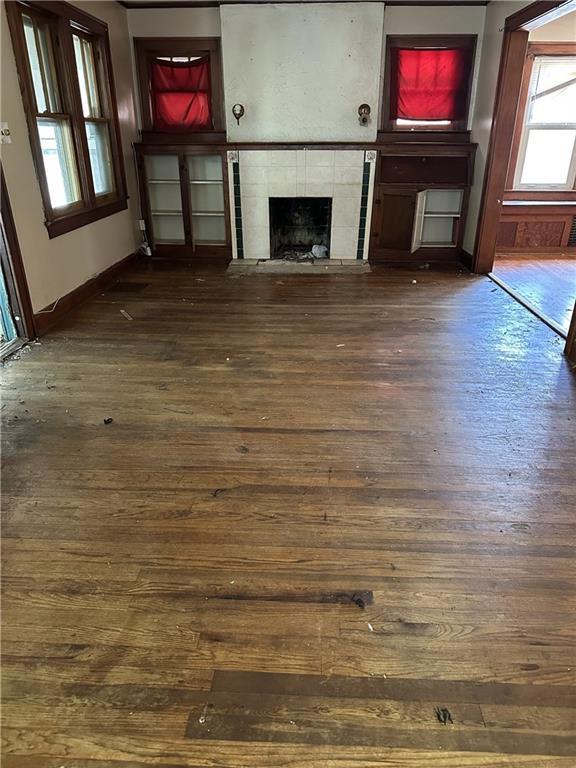 1906 S Willow Ave, Independence, MO 64052 - unfurnished living room with dark wood-type flooring and a fireplace