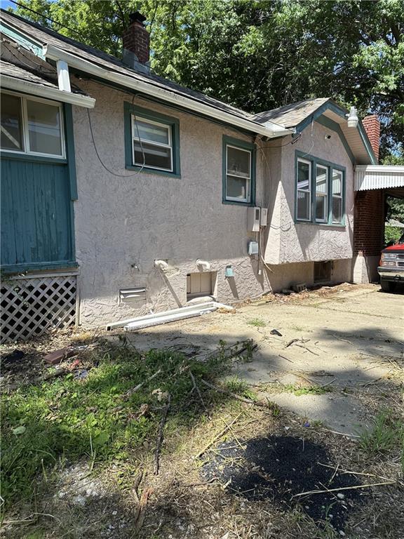 1906 S Willow Ave, Independence, MO 64052 - view of home's exterior featuring a chimney and stucco siding