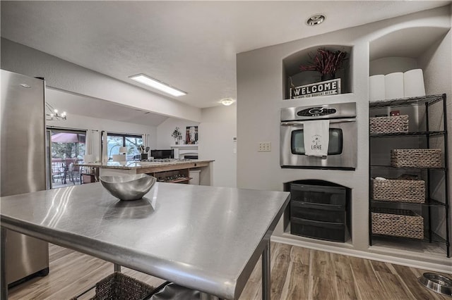 792 195th St, Fort Scott, KS 66701 - kitchen featuring stainless steel countertops, stainless steel appliances, wood finished floors, and lofted ceiling