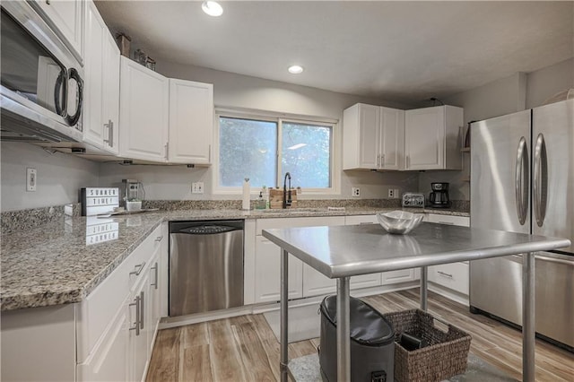 792 195th St, Fort Scott, KS 66701 - kitchen with stainless steel appliances, white cabinets, light wood finished floors, recessed lighting, and light stone counters