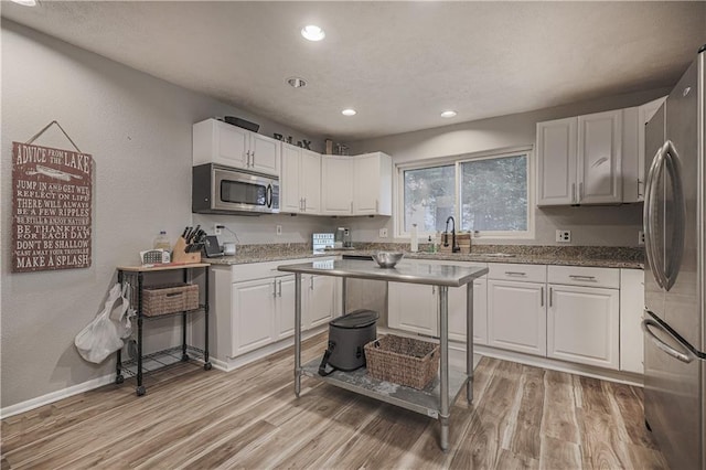 792 195th St, Fort Scott, KS 66701 - kitchen featuring stainless steel appliances, light wood finished floors, white cabinets, a textured wall, and recessed lighting