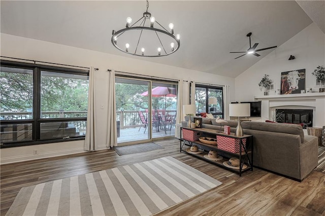792 195th St, Fort Scott, KS 66701 - living room featuring wood finished floors, a chandelier, a ceiling fan, a glass covered fireplace, and high vaulted ceiling
