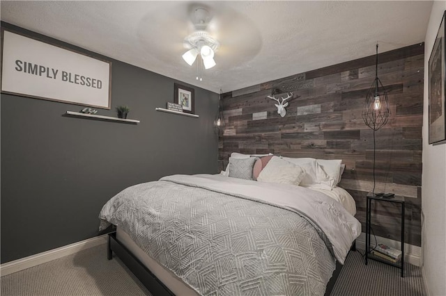 792 195th St, Fort Scott, KS 66701 - bedroom featuring an accent wall, wood walls, carpet floors, and ceiling fan