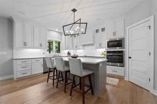 13 Tahoma Rdg, Lake Winnebago, MO 64034 - kitchen with stainless steel appliances, a chandelier, backsplash, a breakfast bar area, and recessed lighting