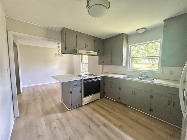 13006 Byars Rd, Grandview, MO 64030 - kitchen featuring white range with electric stovetop, under cabinet range hood, a peninsula, backsplash, and light wood-style flooring