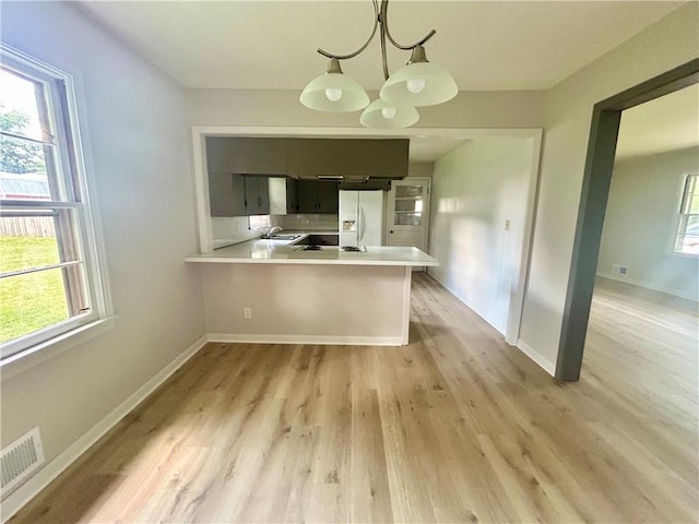 13006 Byars Rd, Grandview, MO 64030 - kitchen featuring white refrigerator with ice dispenser, plenty of natural light, and light countertops
