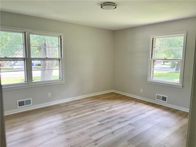 13006 Byars Rd, Grandview, MO 64030 - empty room featuring healthy amount of natural light and light wood-style floors