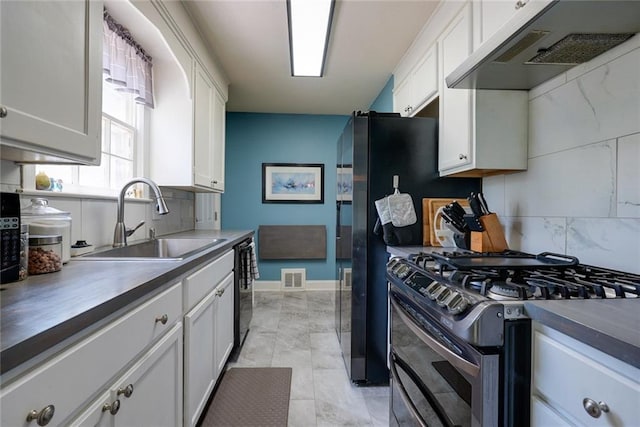 1421 W 28th Ter, Independence, MO 64052 - kitchen featuring gas range, exhaust hood, white cabinetry, tasteful backsplash, and dishwasher