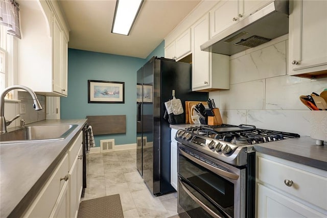 1421 W 28th Ter, Independence, MO 64052 - kitchen featuring double oven range, under cabinet range hood, white cabinets, and backsplash
