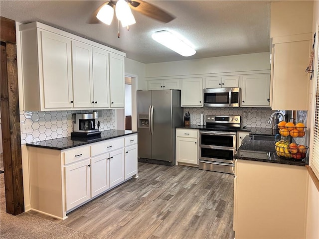 12913 E 41st St S, Independence, MO 64055 - kitchen with stainless steel appliances, ceiling fan, decorative backsplash, white cabinetry, and a textured ceiling