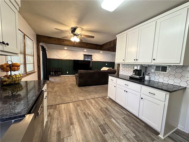 12913 E 41st St S, Independence, MO 64055 - kitchen featuring a ceiling fan, wood finished floors, white cabinetry, wooden walls, and a textured ceiling