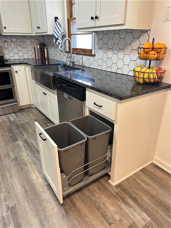 12913 E 41st St S, Independence, MO 64055 - kitchen featuring appliances with stainless steel finishes, dark wood-style flooring, decorative backsplash, and white cabinets