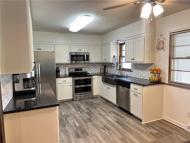 12913 E 41st St S, Independence, MO 64055 - kitchen featuring stainless steel appliances, wood finished floors, backsplash, ceiling fan, and a textured ceiling