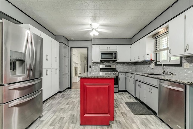 815 N 63rd St, Kansas City, KS 66102 - kitchen featuring stainless steel appliances, tasteful backsplash, light wood-type flooring, white cabinetry, and ceiling fan