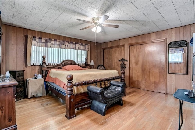 815 N 63rd St, Kansas City, KS 66102 - bedroom with wooden walls, light wood-style floors, two closets, and ceiling fan