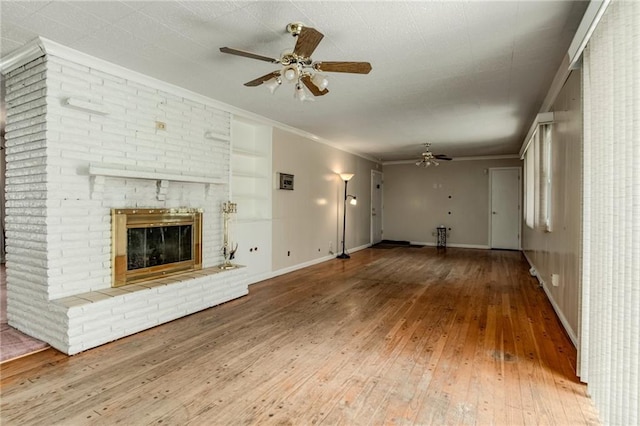 815 N 63rd St, Kansas City, KS 66102 - unfurnished living room with ceiling fan, hardwood / wood-style floors, ornamental molding, a fireplace, and built in shelves