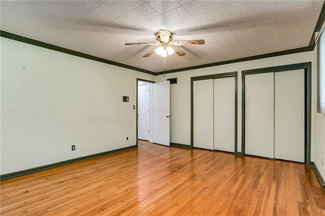 815 N 63rd St, Kansas City, KS 66102 - unfurnished bedroom featuring two closets, wood-type flooring, crown molding, and a ceiling fan