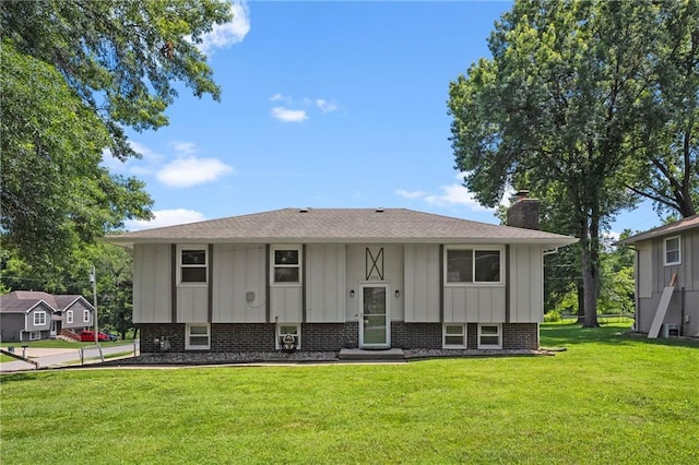 1301 Quincy St, Leavenworth, KS 66048 - view of front of property with board and batten siding, a chimney, a front lawn, a shingled roof, and brick siding