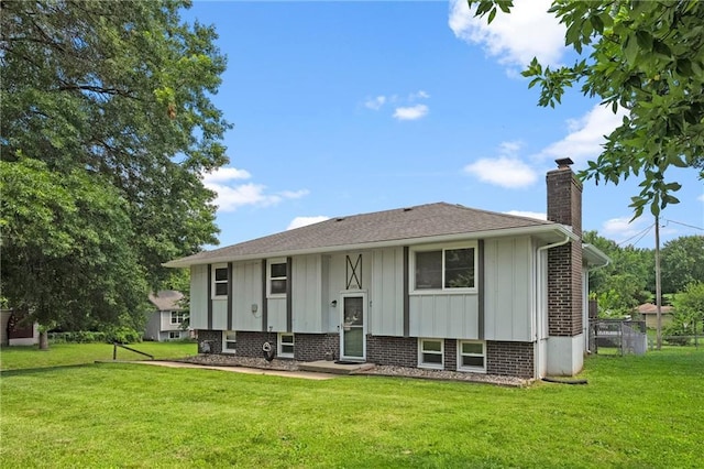 1301 Quincy St, Leavenworth, KS 66048 - view of front of house with board and batten siding, a chimney, and a front lawn