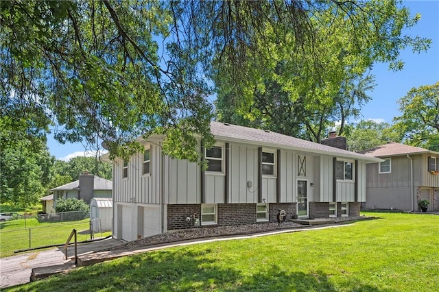 1301 Quincy St, Leavenworth, KS 66048 - split foyer home featuring board and batten siding, brick siding, a garage, a chimney, and driveway