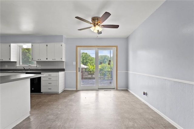 1301 Quincy St, Leavenworth, KS 66048 - kitchen with dark countertops, a ceiling fan, white cabinetry, and tasteful backsplash