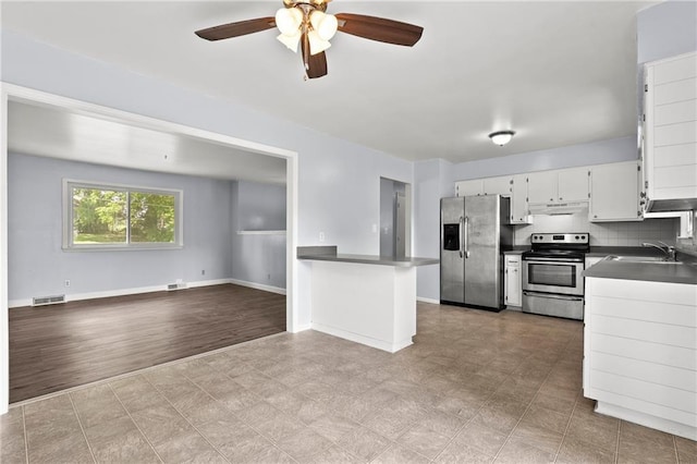 1301 Quincy St, Leavenworth, KS 66048 - kitchen with stainless steel appliances, a ceiling fan, dark countertops, open floor plan, and tile patterned floors