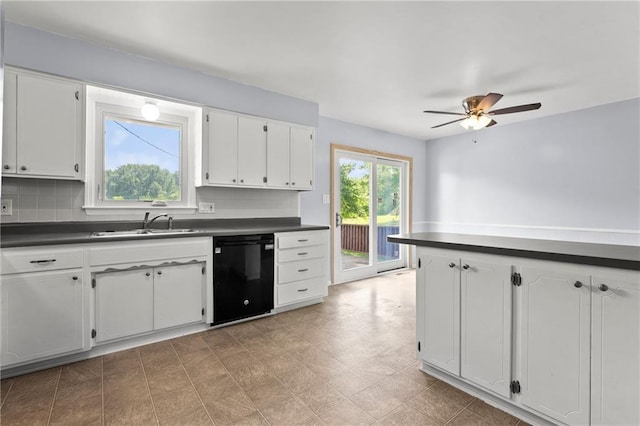 1301 Quincy St, Leavenworth, KS 66048 - kitchen with black dishwasher, dark countertops, ceiling fan, tasteful backsplash, and white cabinetry