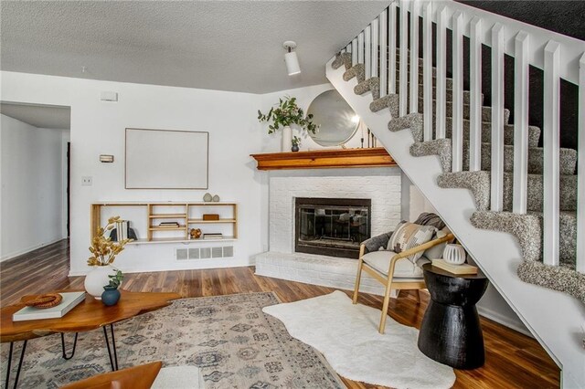 512 NE Brookwood Cir Unit A, Blue Springs, MO 64014 - living room with a brick fireplace, wood finished floors, stairway, and a textured ceiling