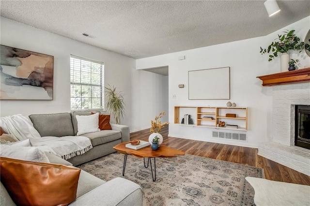 512 NE Brookwood Cir Unit A, Blue Springs, MO 64014 - living room with wood finished floors, a textured ceiling, and a brick fireplace