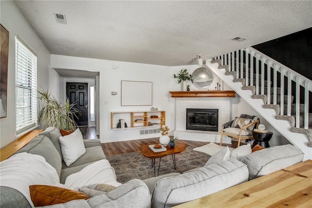512 NE Brookwood Cir Unit A, Blue Springs, MO 64014 - living room featuring wood finished floors, a textured ceiling, a fireplace, and stairs
