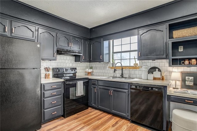 512 NE Brookwood Cir Unit A, Blue Springs, MO 64014 - kitchen with black appliances, under cabinet range hood, light countertops, light wood-type flooring, and a textured ceiling