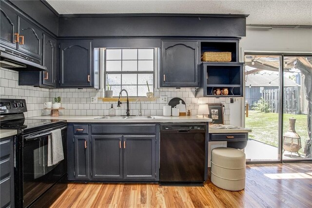 512 NE Brookwood Cir Unit A, Blue Springs, MO 64014 - kitchen featuring black appliances, light wood-style floors, under cabinet range hood, and light countertops
