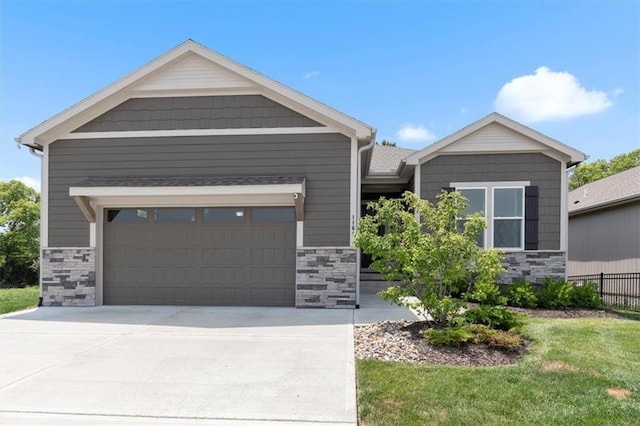 1161 SW Whitby Dr, Lees Summit, MO 64083 - craftsman-style home with stone siding, an attached garage, and driveway