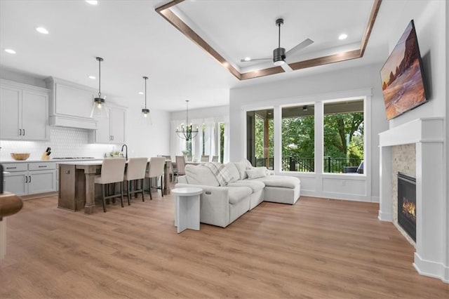 1161 SW Whitby Dr, Lees Summit, MO 64083 - living room featuring plenty of natural light, ceiling fan, light wood-style flooring, a fireplace, and recessed lighting