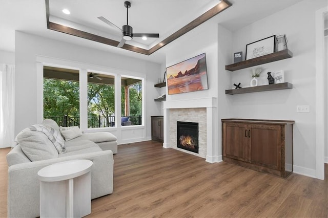 1161 SW Whitby Dr, Lees Summit, MO 64083 - living room with ceiling fan, light wood finished floors, a lit fireplace, and recessed lighting