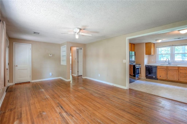 7028 Walmer St, Overland Park, KS 66204 - unfurnished living room featuring light wood-style floors, ceiling fan, and a textured ceiling