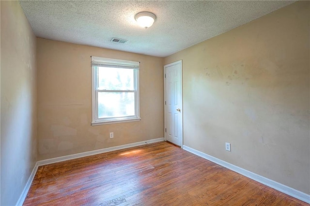 7028 Walmer St, Overland Park, KS 66204 - spare room featuring wood finished floors and a textured ceiling