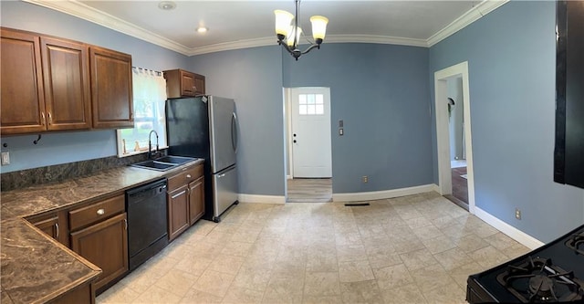108 W Main St, Arma, KS 66712 - kitchen with black dishwasher, dark countertops, freestanding refrigerator, a chandelier, and ornamental molding