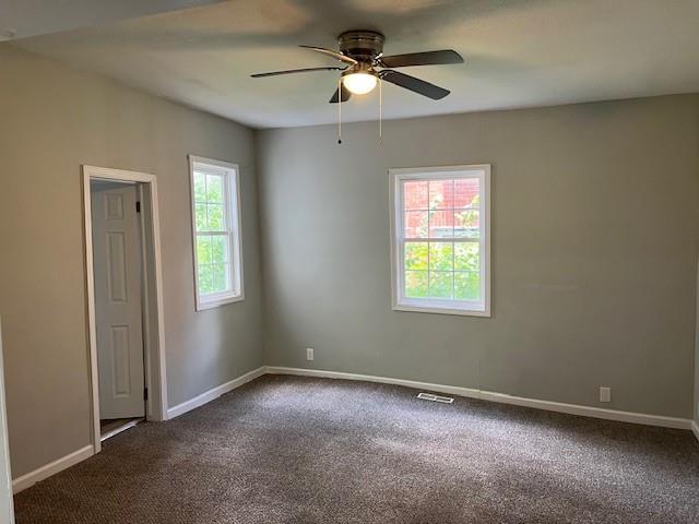 1120 S 20th St, Saint Joseph, MO 64507 - empty room featuring ceiling fan and dark colored carpet