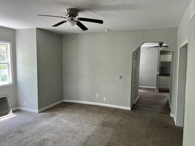 1120 S 20th St, Saint Joseph, MO 64507 - unfurnished living room featuring a ceiling fan, carpet, and arched walkways