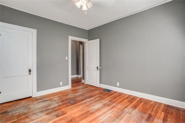 1401 E Mechanic Ave, Independence, MO 64050 - unfurnished bedroom featuring wood finished floors, ornamental molding, and a ceiling fan