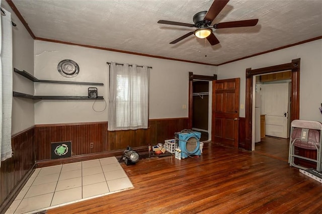 230 N 300th Rd, Overbrook, KS 66524 - unfurnished dining area featuring wood finished floors, ceiling fan, a wainscoted wall, wood walls, and crown molding