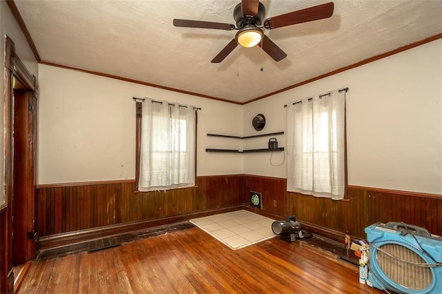 230 N 300th Rd, Overbrook, KS 66524 - spare room with hardwood / wood-style flooring, a wainscoted wall, wood walls, and a ceiling fan