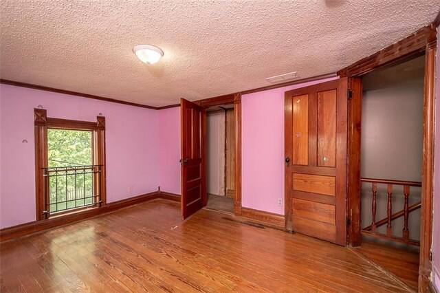 230 N 300th Rd, Overbrook, KS 66524 - empty room with wood-type flooring, a textured ceiling, and ornamental molding