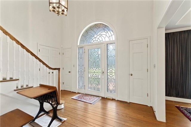 14908 E Pawhuska Rd, Nevada, MO 64772 - entrance foyer with hardwood / wood-style flooring, a high ceiling, stairs, and a chandelier