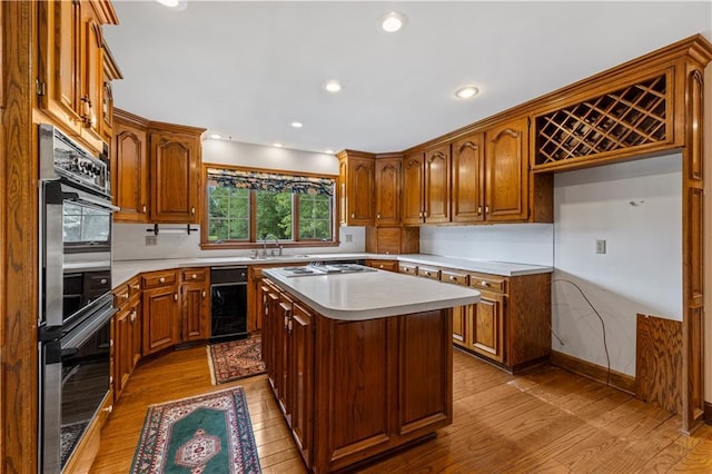 14908 E Pawhuska Rd, Nevada, MO 64772 - kitchen with light wood-type flooring, light countertops, stainless steel stovetop, a kitchen island, and recessed lighting